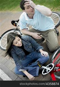 High angle view of a mid adult couple sitting with bicycles and smiling