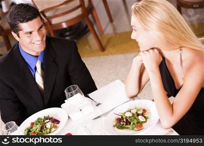 High angle view of a mid adult man and a young woman sitting at a table in a restaurant