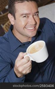 High angle view of a mid adult man holding a cup of tea
