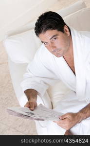 High angle view of a mid adult man holding a newspaper