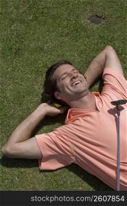 High angle view of a mid adult man lying on a golf course
