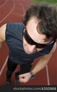 High angle view of a mid adult man running on a running track