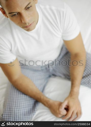 High angle view of a mid adult man sitting on the bed