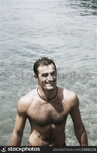 High angle view of a mid adult man standing in a river and smiling