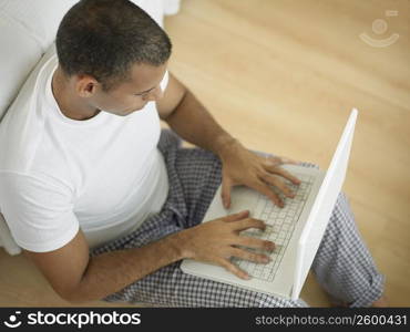 High angle view of a mid adult man using a laptop