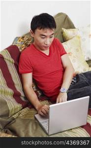 High angle view of a mid adult man using a laptop