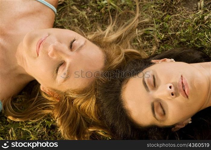 High angle view of a mid adult woman and a mature woman lying on the grass