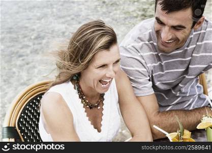 High angle view of a mid adult woman laughing with a mid adult man looking at her