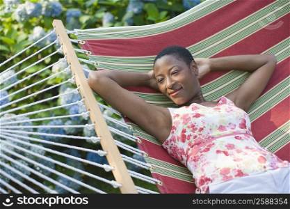 High angle view of a mid adult woman lying in a hammock and smiling
