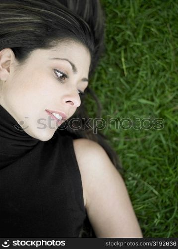 High angle view of a mid adult woman lying on a lawn