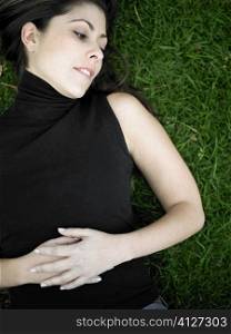 High angle view of a mid adult woman lying on a lawn