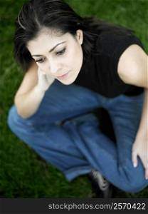 High angle view of a mid adult woman sitting on a lawn