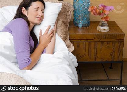 High angle view of a mid adult woman sleeping on the bed
