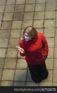 High angle view of a mid adult woman smoking a cigarette