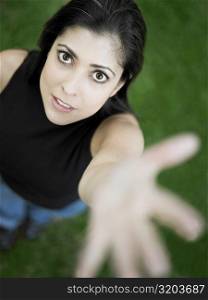 High angle view of a mid adult woman standing with her hand raised