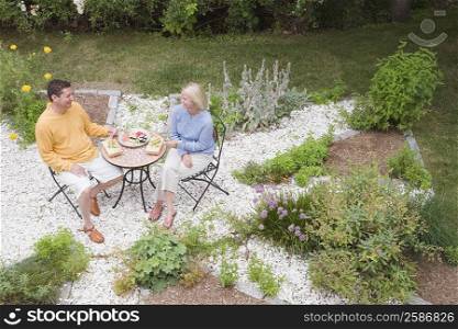 High angle view of a mid adult woman with a mature man having lunch in a garden