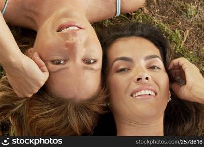 High angle view of a mid adult woman with a mature woman lying on the grass