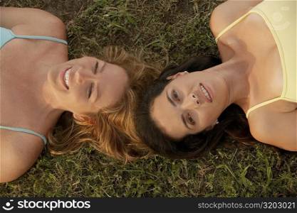 High angle view of a mid adult woman with a mature woman lying on the grass
