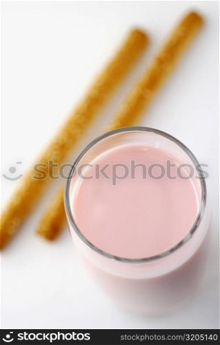 High angle view of a milkshake with two breadsticks