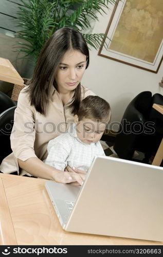 High angle view of a mother using a laptop with her son