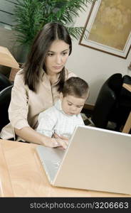 High angle view of a mother using a laptop with her son