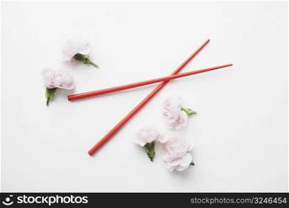 High angle view of a pair of chopsticks and flowers