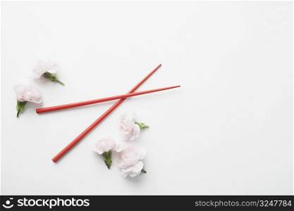 High angle view of a pair of chopsticks and flowers