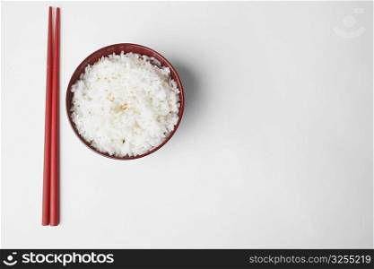 High angle view of a pair of chopsticks near a bowl of rice