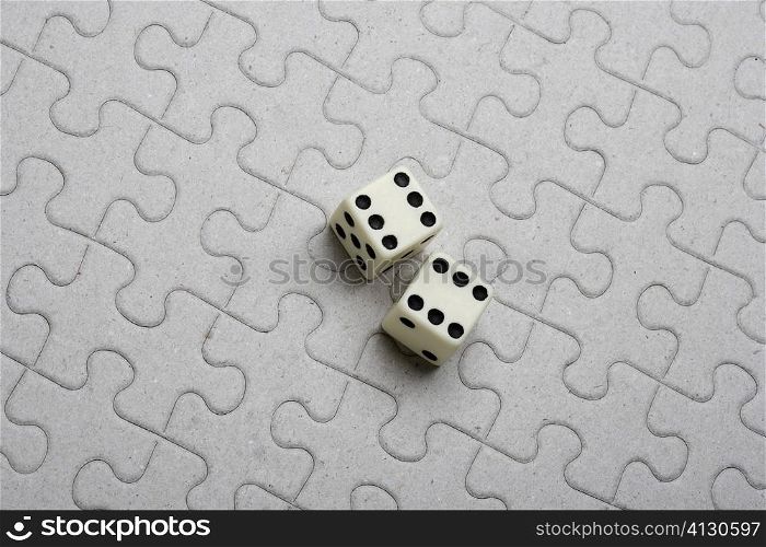 High angle view of a pair of dice on a jigsaw puzzle