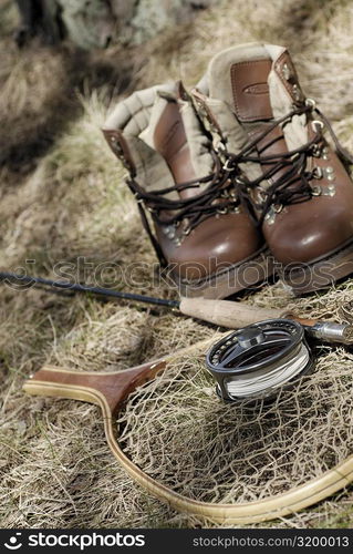 High angle view of a pair of wading boots and fishing equipment