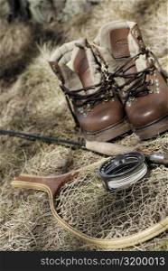 High angle view of a pair of wading boots and fishing equipment