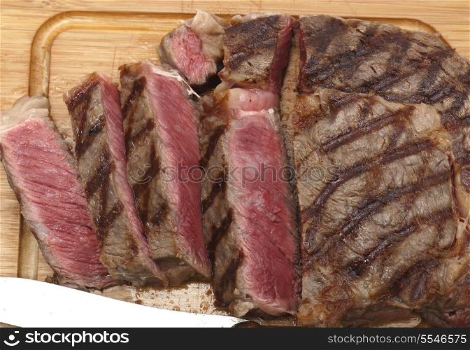 High angle view of a partly-sliced grilled wagyu beef ribeye steak viewed from above
