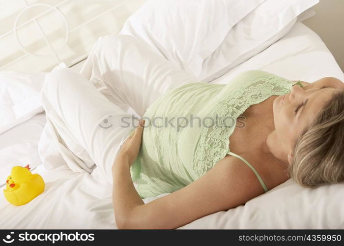 High angle view of a pregnant woman resting on the bed