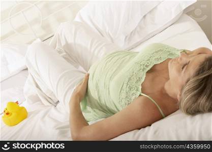 High angle view of a pregnant woman resting on the bed