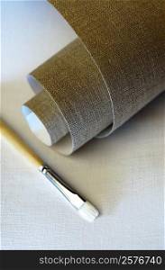 High angle view of a roll of canvas and a paintbrush
