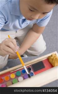 High angle view of a schoolboy painting in an art class