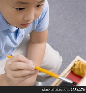 High angle view of a schoolboy painting in an art class