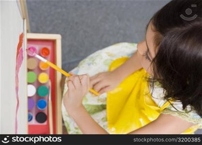High angle view of a schoolgirl painting in an art class