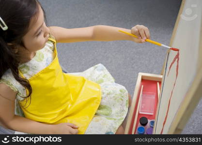 High angle view of a schoolgirl painting in an art class