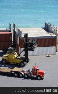 High angle view of a semi-truck and a forklift at a commercial dock