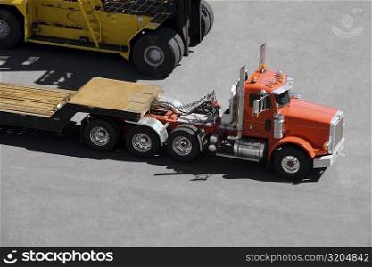 High angle view of a semi-truck and a forklift at a commercial dock