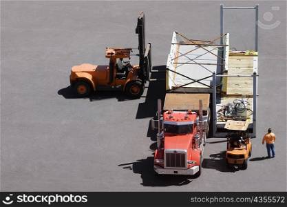 High angle view of a semi-truck and forklifts at a commercial dock
