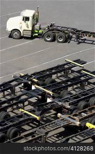High angle view of a semi-truck with vehicle trailers at a commercial dock
