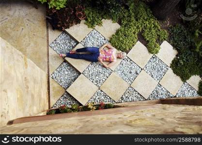High angle view of a senior woman lying in a garden