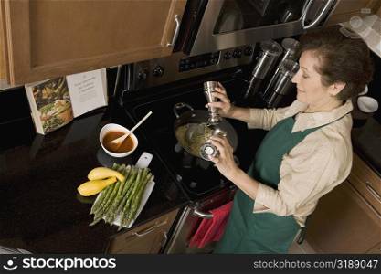 High angle view of a senior woman preparing noodles in the kitchen