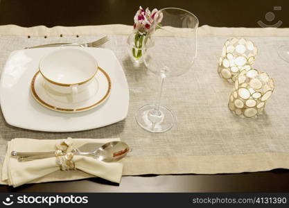 High angle view of a soup bowl with a wine glass on a dining table