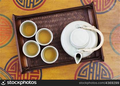 High angle view of a teapot and tea cups in a tray