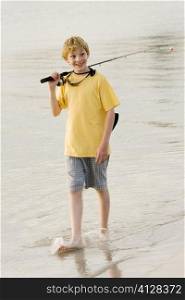 High angle view of a teenage boy walking in a lake with a fishing rod