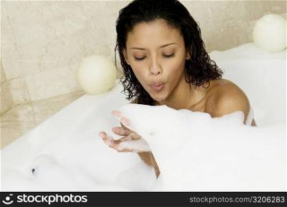 High angle view of a teenage girl blowing soap suds
