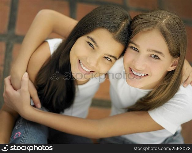 High angle view of a teenage girl hugging her sister